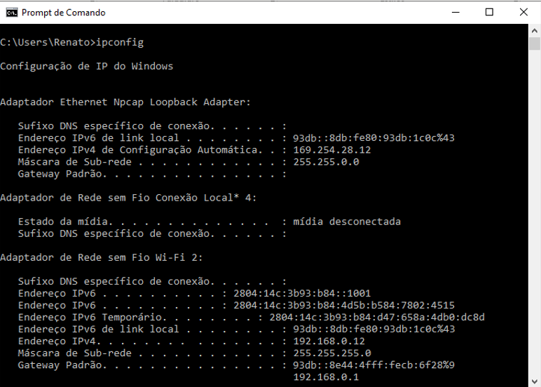 A imagem mostra a captura de tela do prompt de comando do sistema operacional com o comando ipconfig e mostra a configuração de IP do Windows: Adaptador Ethernet, com endereço IPv6, IPv4 e máscara de rede, Adaptador de Rede sem Fio Conexão Local* 4,  com o estado da mídia, Adaptador de Rede sem Fio Wifi 2, como endereço IPv6, endereço IPv6 temporário, endereço IPv6 de link local, endereço IPv4,  máscara de sub-rede e gateway padrão.